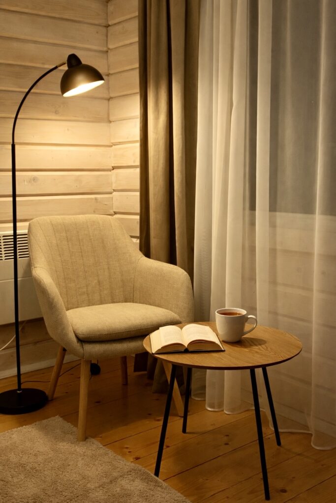 Світла спальня з натурального дерева з облаштованим куточком для читання. Насолоджуйтесь відпочинком на преміальній сатиновій білизні з велюровим покривалом кольору капучино. М’яке крісло біля вікна та торшер створюють ідеальну атмосферу для релаксу.