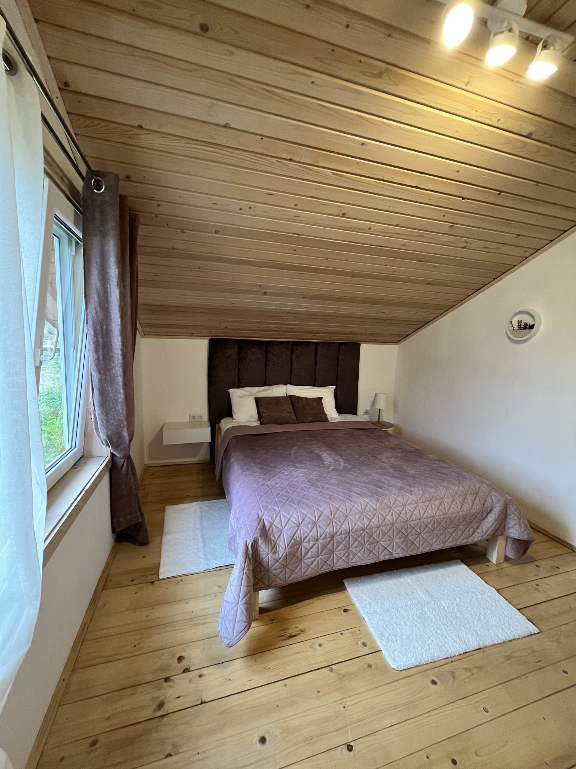 Сучасна спальня у котеджі в Карпатах з ліжком і настільною лампою